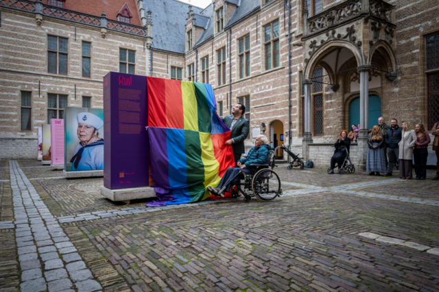 Bewoner John opent samen met de wethouder de expositie Oud Roze op de binnenplaats van Het Markiezenhof in Bergen op Zoom