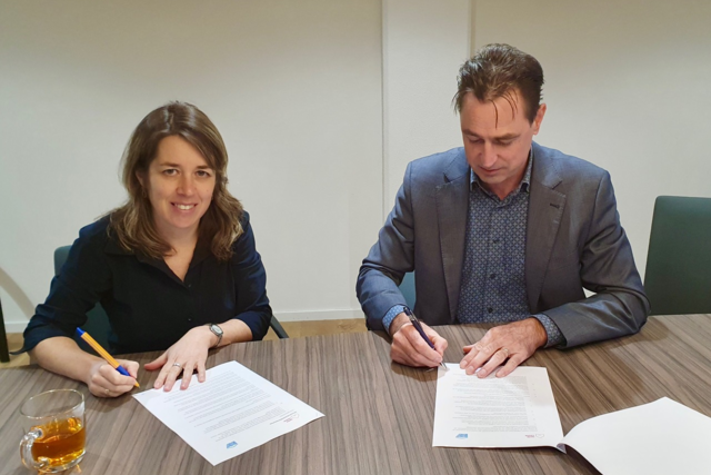 Ingeborg Roks en Con Mol zitten samen aan tafel en tekenen de intentieovereenkomst