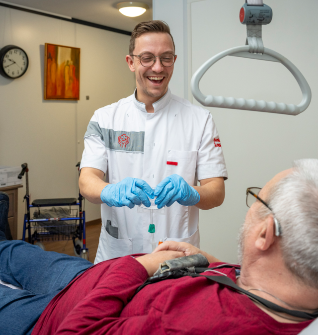 Verpleegkundige aan het bed bijeen bewoner