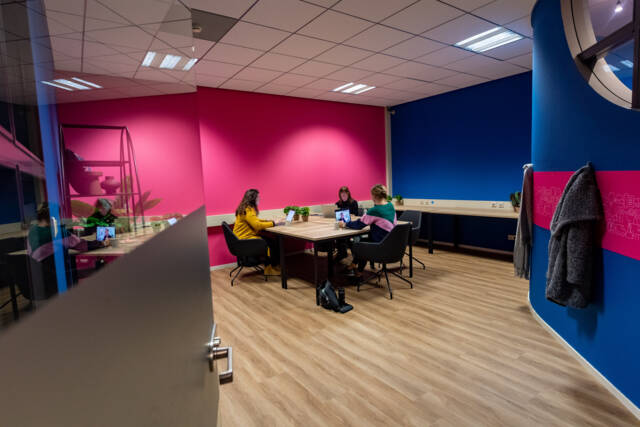 Een vergaderruimte in tante's Zorglab met roze en blauwe muren