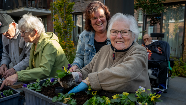 Een bewoner van tanteLouise werkt samen met haar naaste in de moestuin