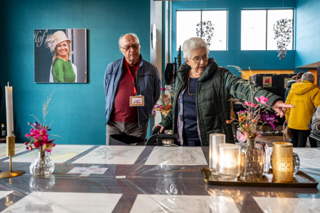 Bezoekers van de expositie kijken naar de uitgestalde werken