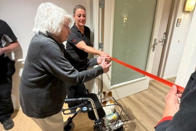 Een bewoonster van Stuijvenburgh knipt symbolisch het lintje door.