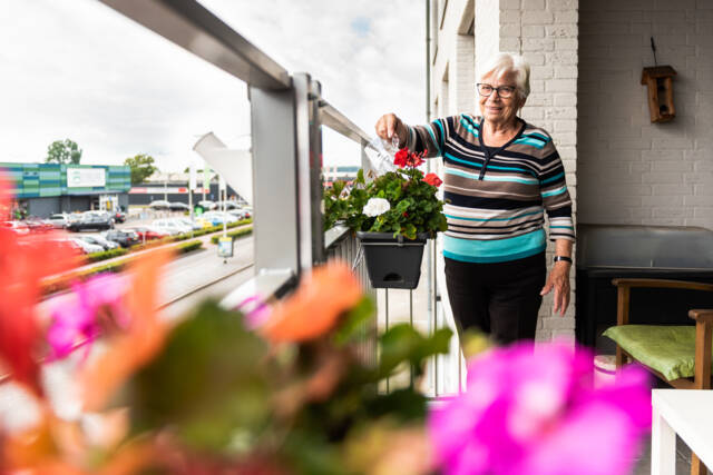 Een bewoner van tanteLouise geeft de planten water
