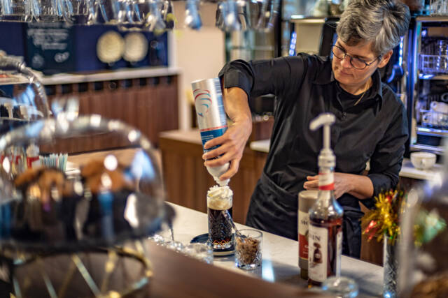 Een medewerker van de brasserie maakt een Irish coffee