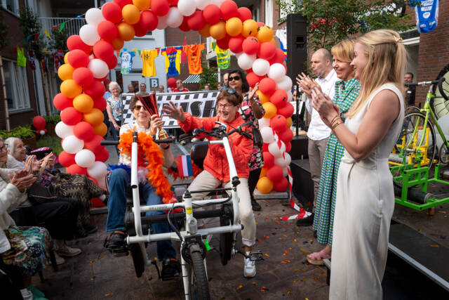 Een bewoner en vrijwilliger van Hoogerwaard reden over de finishlijn tijdens de officiele opening van het nieuwe verpleeghuis