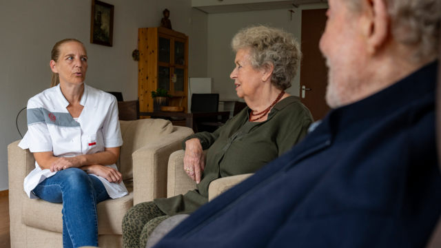 Een medewerker van tanteLouise in gesprek met een bewoner en zijn vrouw