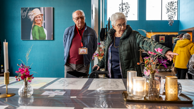 Bezoekers van de expositie kijken naar de uitgestalde werken