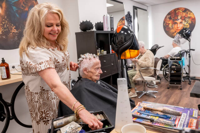 De kapster in de kapsalon van Onze Stede
